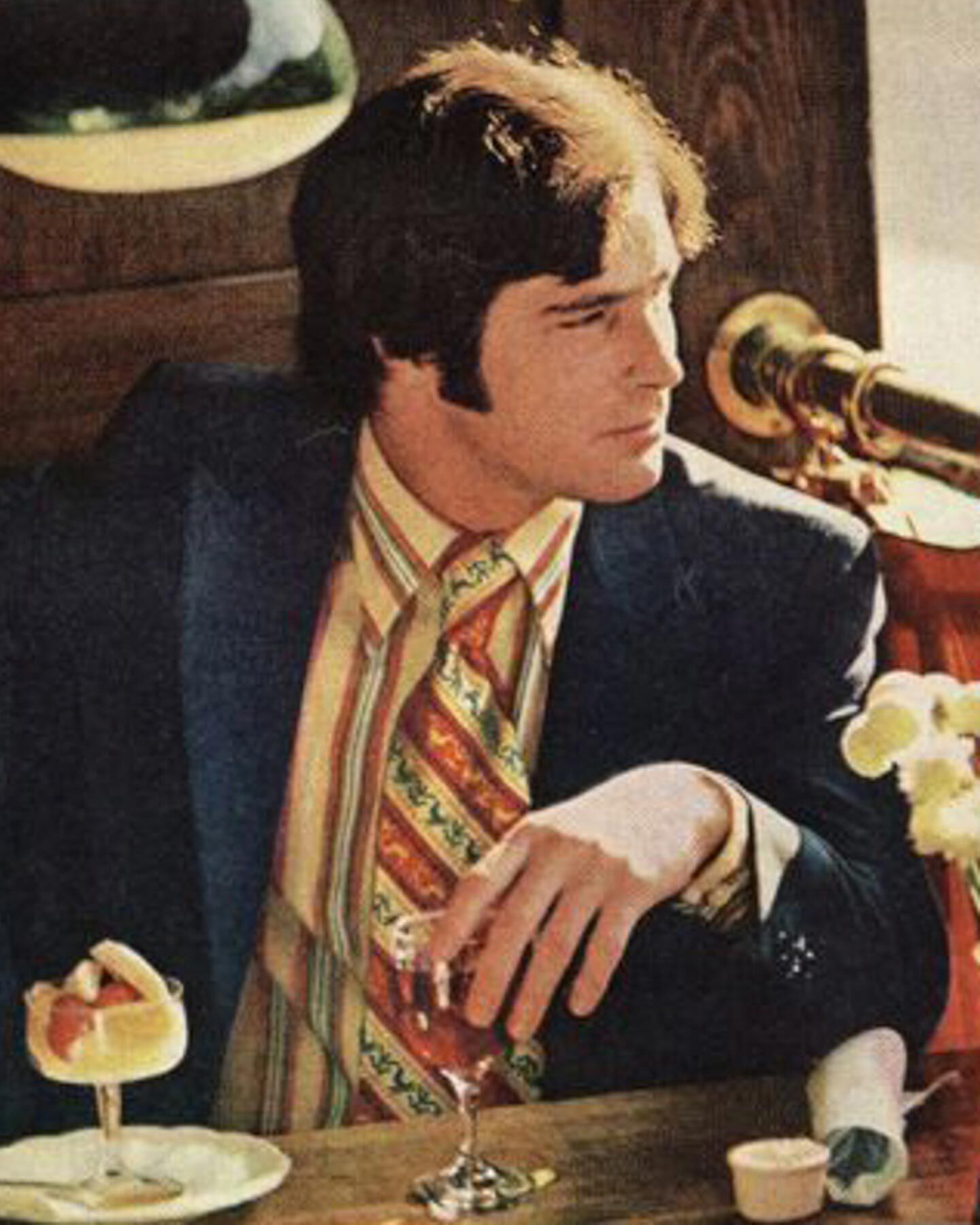 Men wearing Gant suit sitting at a table with a drink